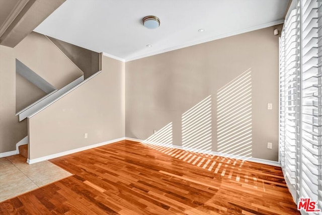 empty room featuring hardwood / wood-style flooring and ornamental molding