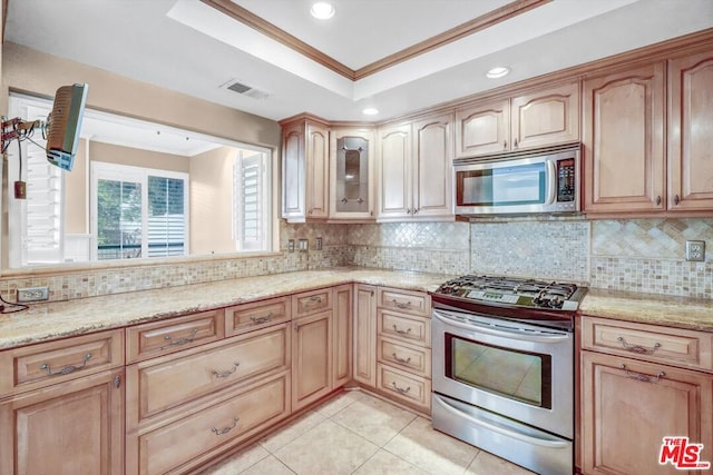 kitchen featuring light stone counters, backsplash, appliances with stainless steel finishes, light tile patterned floors, and ornamental molding