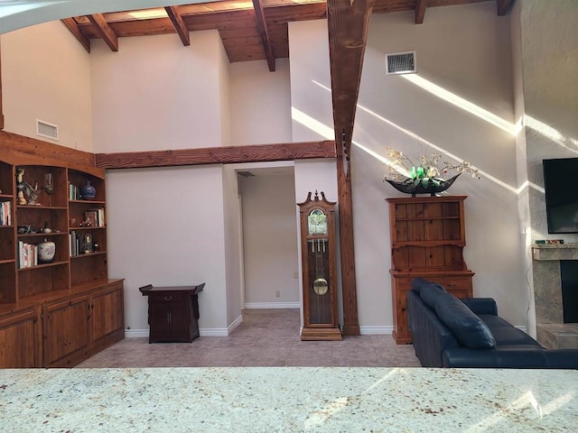 living room featuring light tile patterned floors, high vaulted ceiling, a fireplace, wooden ceiling, and beamed ceiling