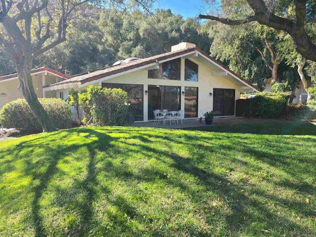 back of property with a patio area and a lawn