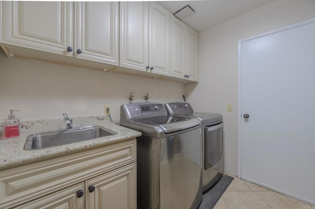 clothes washing area featuring cabinets, sink, light tile patterned floors, and independent washer and dryer