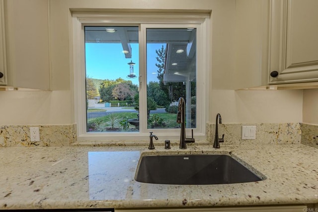 32202 Taupa Way, Pauma Valley, CA 92061 - kitchen featuring a sink, light stone countertops, healthy amount of natural light, and cream cabinetry
