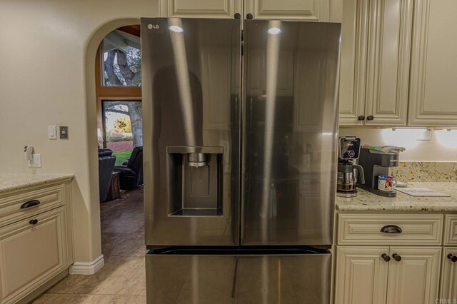 32202 Taupa Way, Pauma Valley, CA 92061 - kitchen featuring stainless steel fridge, cream cabinetry, arched walkways, and light stone counters