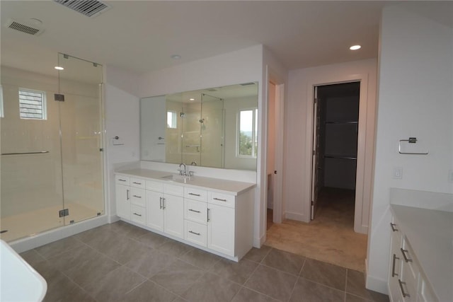 bathroom featuring tile patterned flooring, vanity, and an enclosed shower