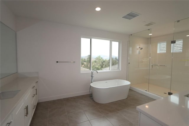 bathroom featuring tile patterned flooring, plus walk in shower, and vanity