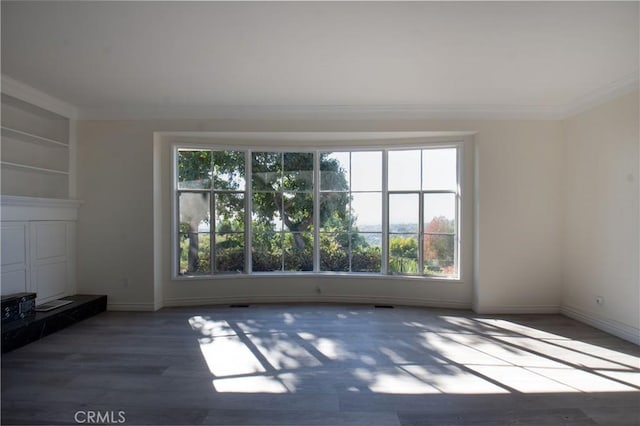 unfurnished living room with built in features, ornamental molding, and dark hardwood / wood-style floors