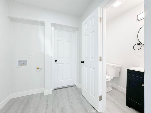 interior space with hardwood / wood-style floors, vanity, and toilet