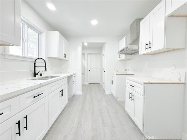 kitchen with white cabinetry, wall chimney exhaust hood, and sink