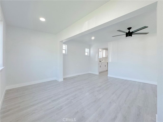 unfurnished room featuring ceiling fan, sink, and light hardwood / wood-style floors