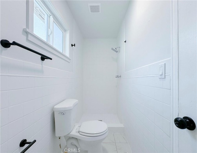 bathroom featuring toilet, tile walls, and walk in shower