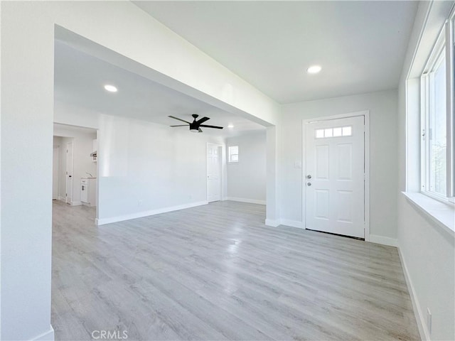 foyer entrance with ceiling fan and light wood-type flooring