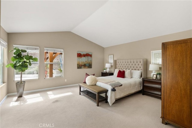 bedroom with light colored carpet and lofted ceiling