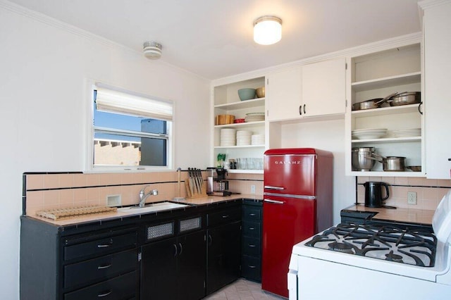 kitchen featuring backsplash, white gas range, crown molding, sink, and white cabinetry