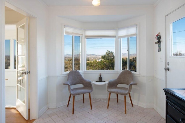 living area featuring a wealth of natural light, crown molding, and light tile patterned floors