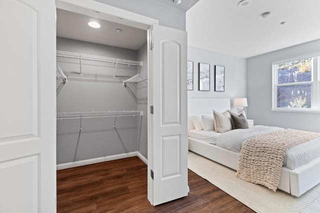 bedroom with dark wood-type flooring and a closet