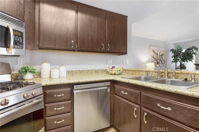 kitchen with dark brown cabinetry, sink, and appliances with stainless steel finishes