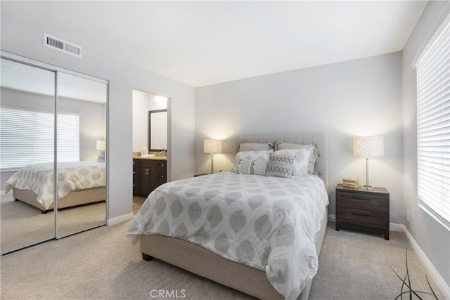 carpeted bedroom featuring ensuite bath and a closet