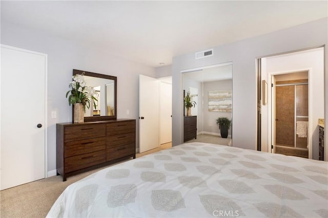 bedroom with light carpet and ensuite bathroom