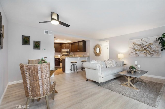 living room featuring ceiling fan and light wood-type flooring