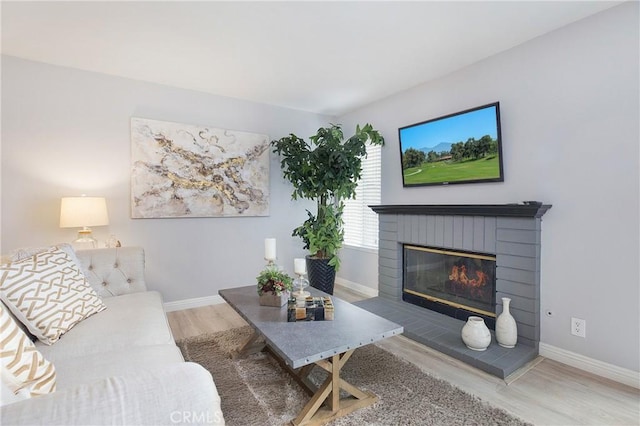 living room with hardwood / wood-style floors and a brick fireplace