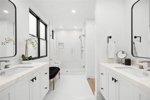 bathroom featuring recessed lighting, a sink, tile patterned flooring, and a shower stall