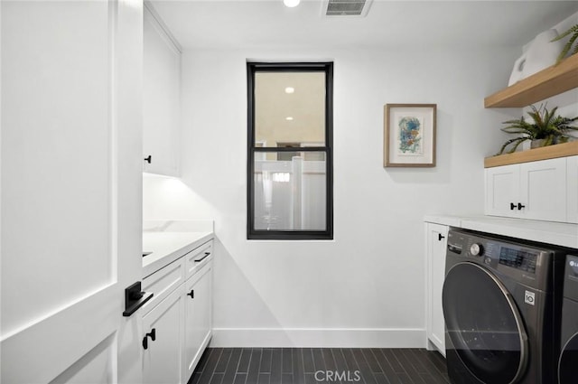 laundry room with cabinets and washing machine and clothes dryer