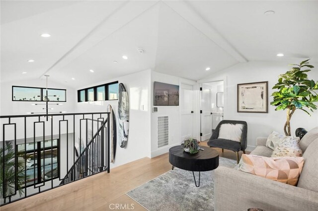 living room with vaulted ceiling with beams and light hardwood / wood-style flooring