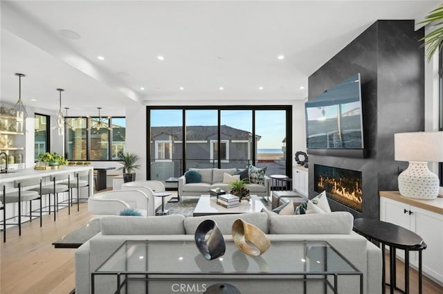 living area featuring recessed lighting, a large fireplace, and wood finished floors