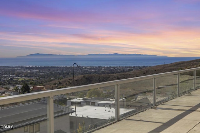 balcony at dusk featuring a mountain view