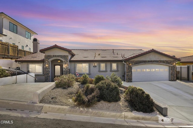 view of front of home featuring stucco siding, an attached garage, stone siding, and concrete driveway