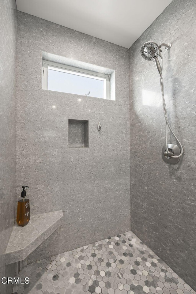 bathroom with a wealth of natural light and tiled shower