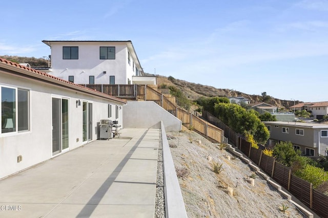 exterior space featuring a residential view, stucco siding, a patio area, and a fenced backyard