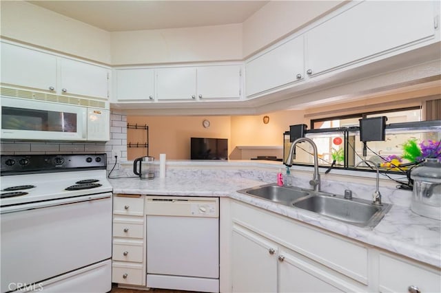 kitchen featuring sink, white cabinets, and white appliances