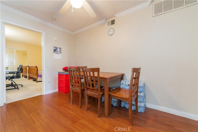 dining space featuring crown molding, hardwood / wood-style floors, and ceiling fan