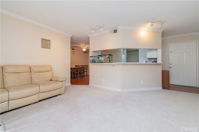 living room with light carpet, track lighting, ceiling fan, and ornamental molding