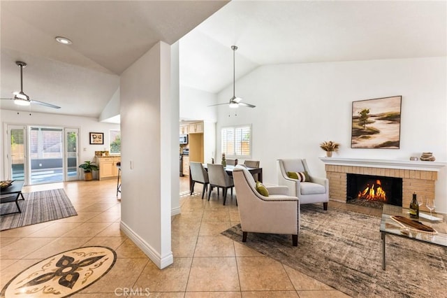 tiled living room with ceiling fan, a wealth of natural light, and vaulted ceiling