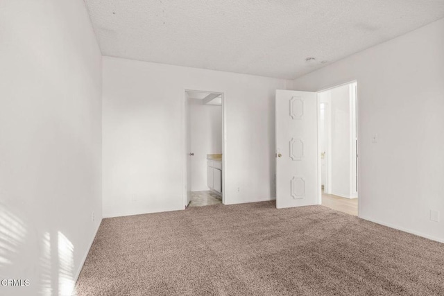 unfurnished bedroom with a textured ceiling and carpet floors