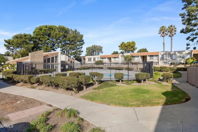 surrounding community with a residential view, fence, a pool, and a yard