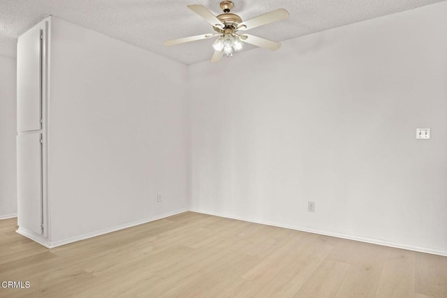 empty room with a textured ceiling, wood finished floors, and a ceiling fan