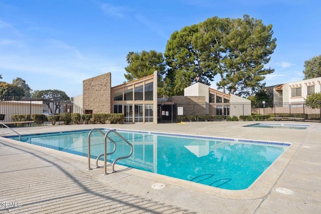 community pool featuring a patio and fence