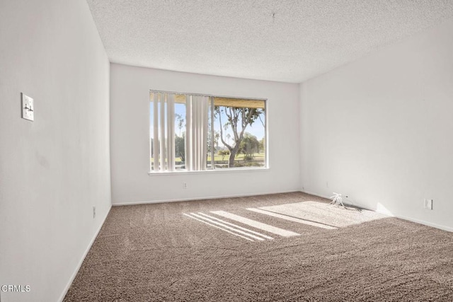 empty room featuring carpet floors, a textured ceiling, and baseboards