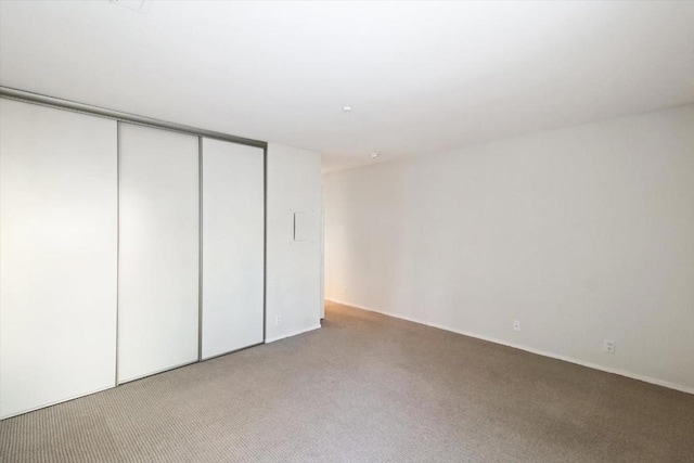 unfurnished bedroom featuring light carpet and a closet