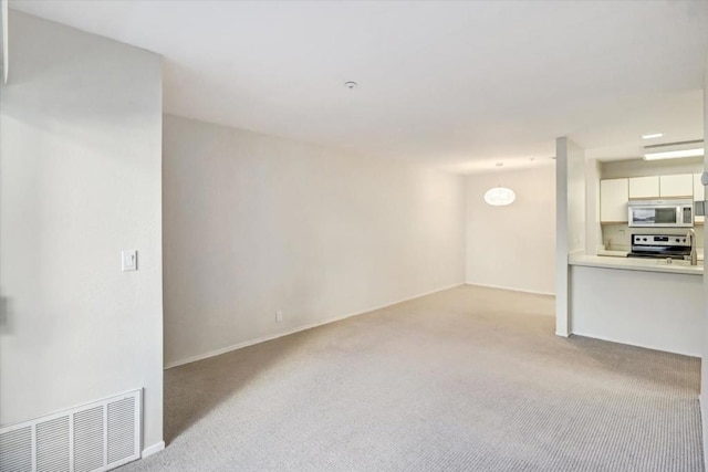 unfurnished living room featuring light carpet