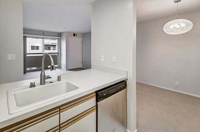 kitchen featuring sink, white cabinetry, stainless steel dishwasher, pendant lighting, and light colored carpet