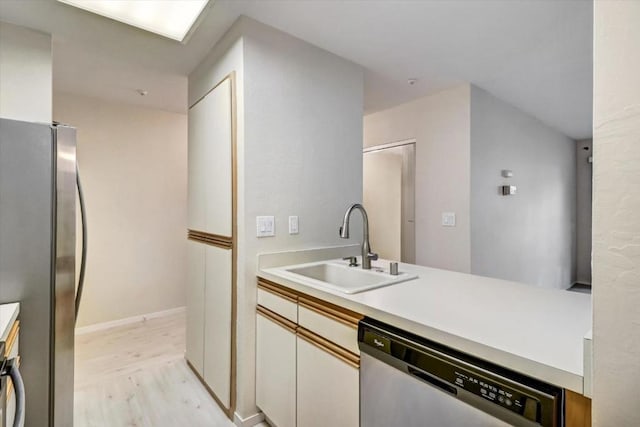 kitchen featuring sink, stainless steel appliances, white cabinets, and light wood-type flooring