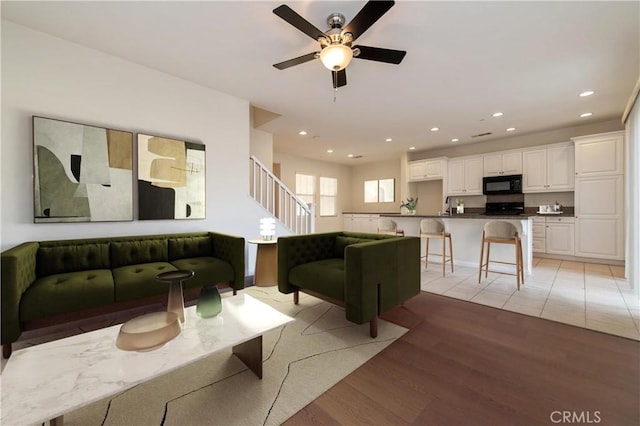 living room featuring light wood-type flooring and ceiling fan