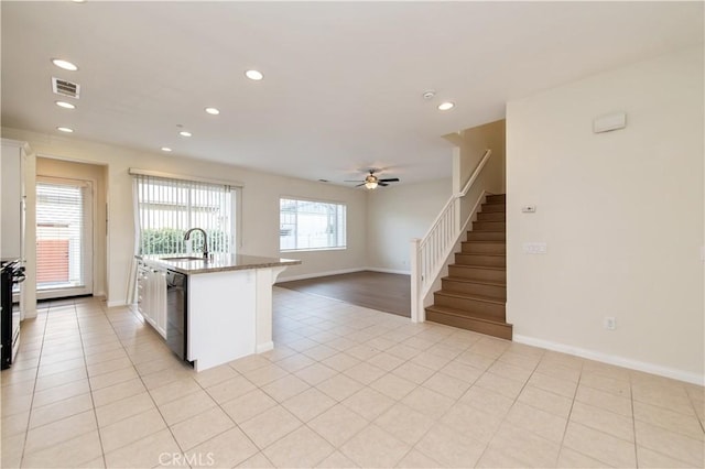 kitchen featuring ceiling fan, sink, black appliances, a center island with sink, and white cabinets