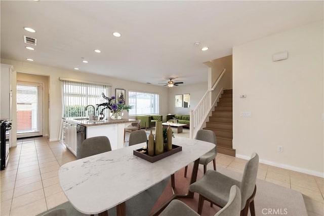 tiled dining space with ceiling fan and sink