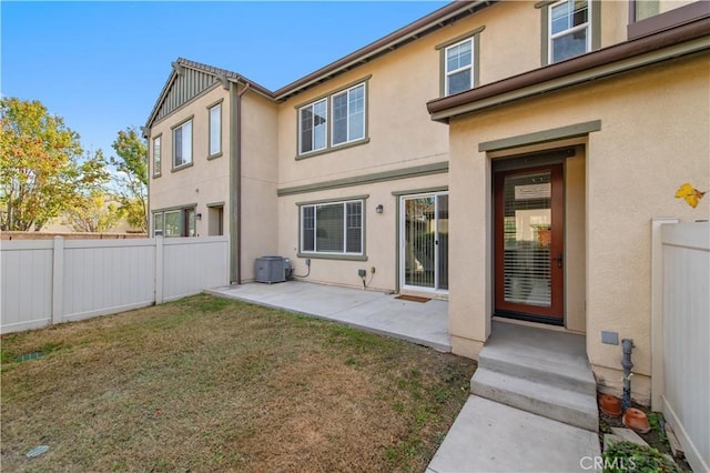 rear view of house featuring a patio, a lawn, and central air condition unit