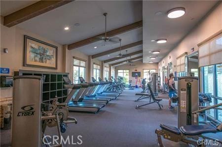 exercise room featuring ceiling fan, carpet floors, and vaulted ceiling